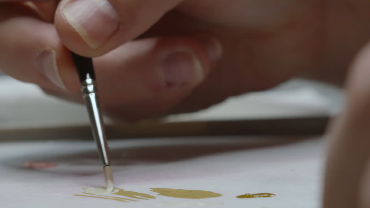 Close Up of Artist Twirling Thin Paintbrush and Mixing Different Colors to Create Unique Look for Painting in Naturally Lit Studio 4K