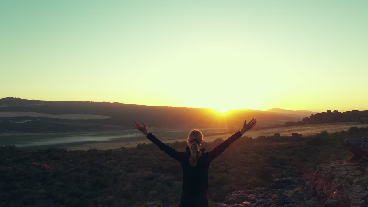 산꼭대기 에서 아름다운 해가 뜨고 해가 지는 풍경을 즐기는 여자