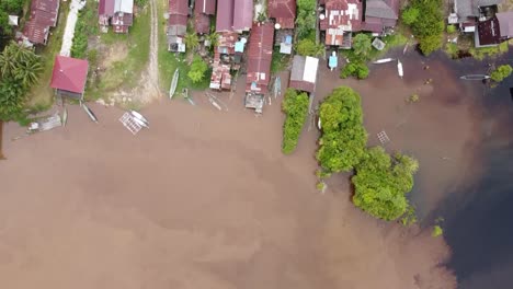 Luftaufnahme-Eines-Kleinen-Tropischen-Dorfes,-Das-Vom-Fluss-Ins-Dorf-Kommt