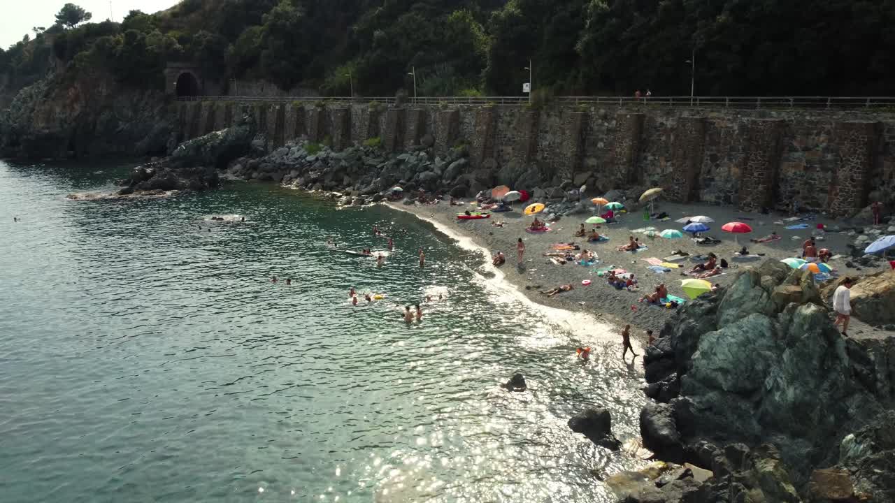 Beach with People Sunbathing and Swimming