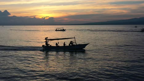 aerial-parallel-of-tourist-boats-crusing-fast-towards-dolphins-at-sunrise-in-Lovina-Bali-Indonesia