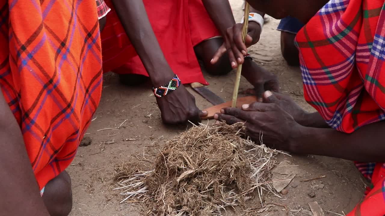 Native people in Massai Mara, Kenia Africa trying to do fire with wood sticks