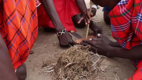 native people in massai mara, kenia africa trying to do fire with wood sticks