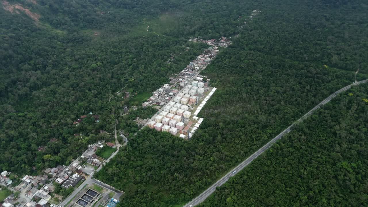 Aerial pan right shot of residential development near highway, Brazil
