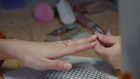 anonymous manicurist using nail buffing block to polish girl's hands, slow motion