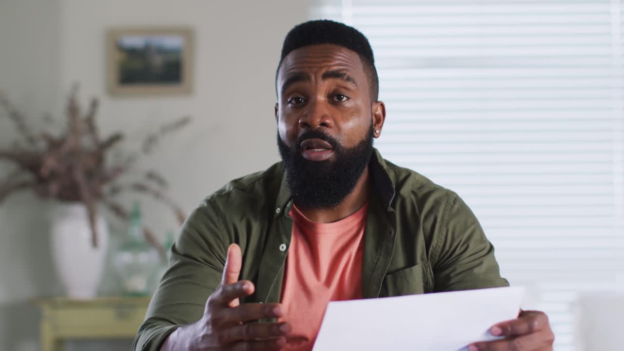 African american man making business video call at home, talking and gesturing, slow motion