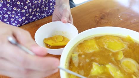 ladling spicy fish soup into bowls