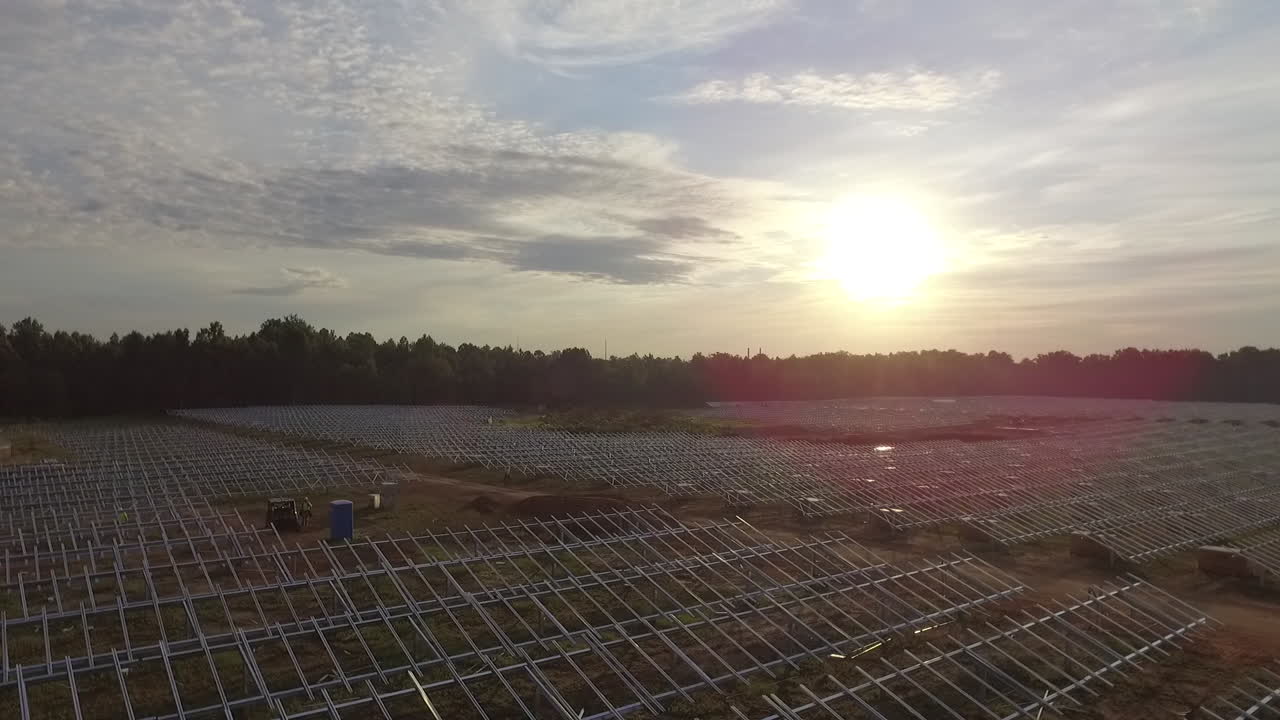 toma de drones de un campo solar en construcción, hacia el sol