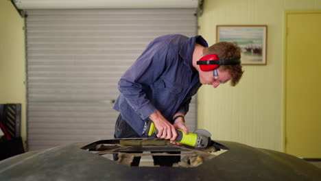 Worker-Man-Grinding-Metal-Sheet-With-Hand-Held-Power-Tool-In-Garage-Workshop,-4K