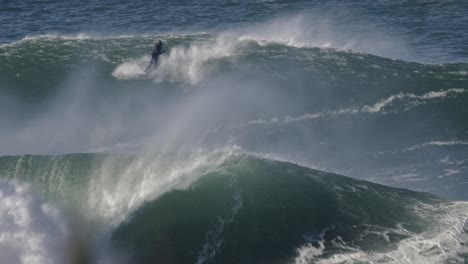 Surfer-gets-pulled-onto-a-wave-by-a-jet-ski-driver-and-performs-a-cool-ride-including-a-360-spin-trick