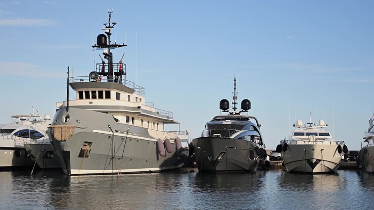 Collezione di yacht di lusso e motoscafi ormeggiati fianco a fianco nel porto turistico di Cannes sotto un cielo azzurro e limpido.