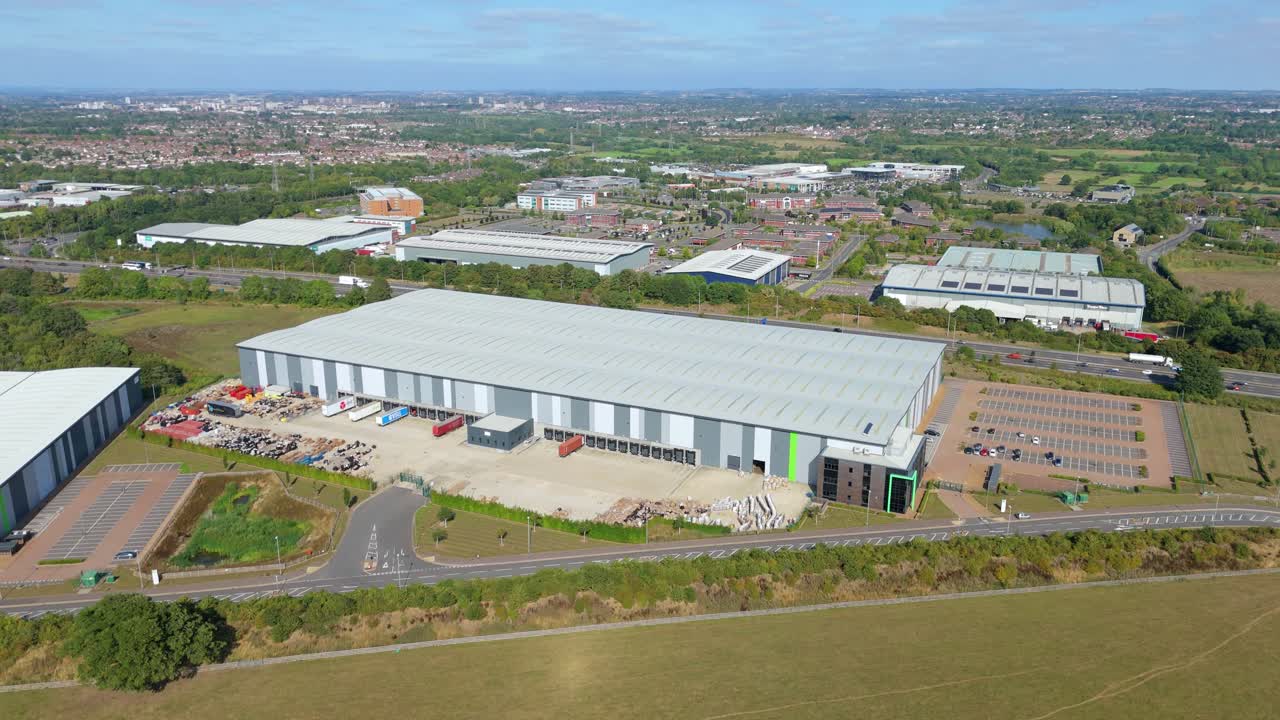 Drone aerial top view of warehouses and logistics centres next to M1 motorway with trucks and vehicles driving at speed Leicester England UK