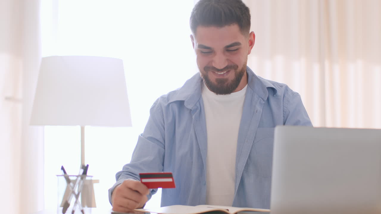 Man Using Credit Card for Online Shopping on Laptop