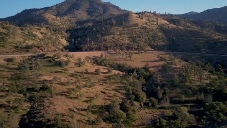 vista aérea de un tren que pasa por el escarpado desierto de california en la hora dorada