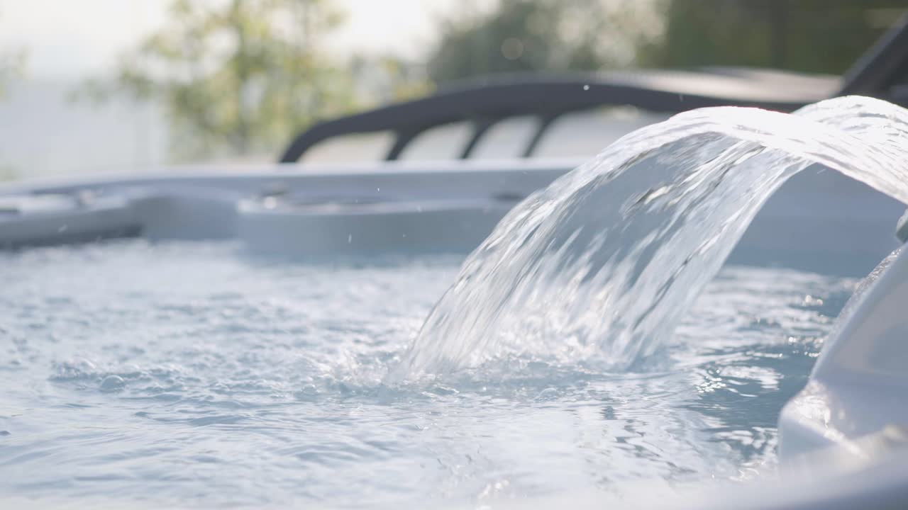 밴쿠버 서부의 고급 주택 야외 자쿠지에서 물이 튀고 부글거리는 모습을 클로즈업한 영화 같은 장면이에요.