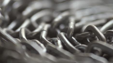 la cadena de metal gira lentamente. los eslabones de la cadena se mueven. fondo industrial. cerrar