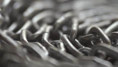 the metal chain slowly rotate. chain links move. industrial background. close up