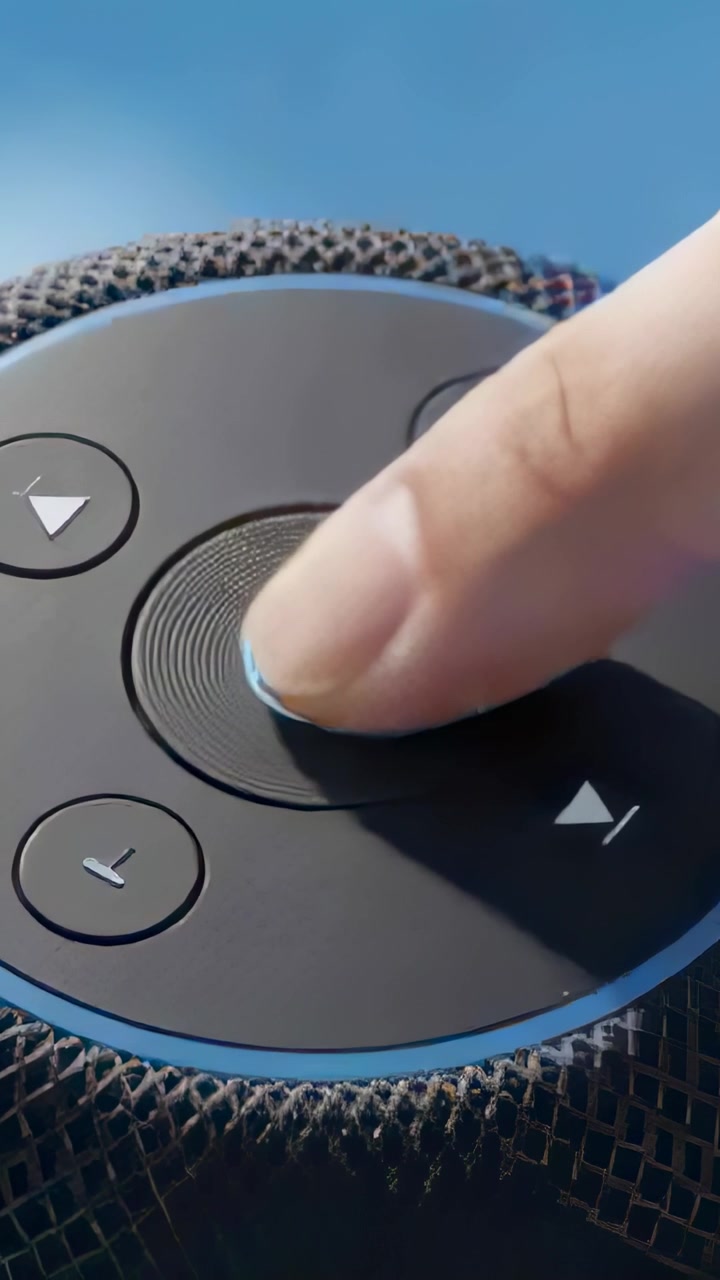 Vertical video: Approaching index finger activating textured dial on blue surface with glowing LED