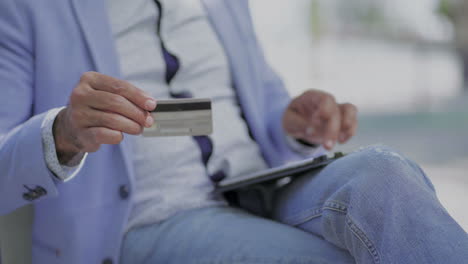 Cropped-shot-of-man-with-credit-card-using-digital-tablet