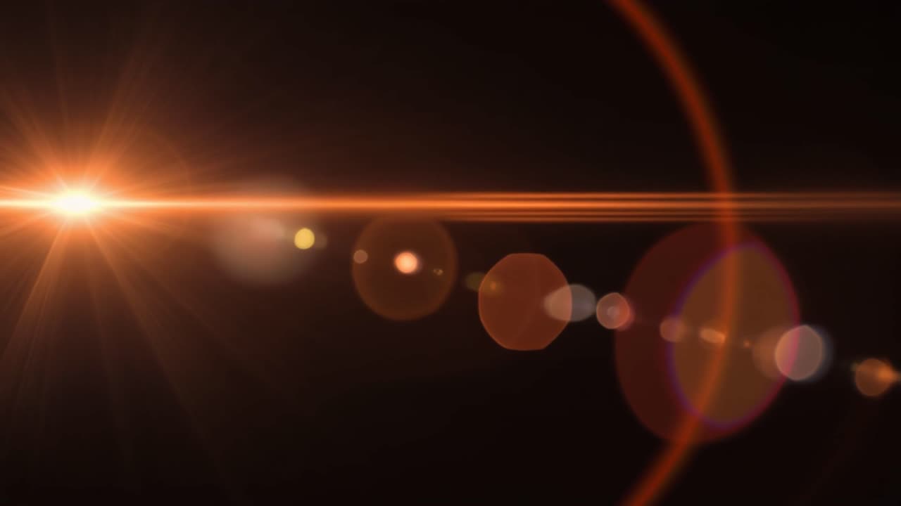 Bagliore dinamico arancione dell'obiettivo con effetto Bokeh su sfondo nero