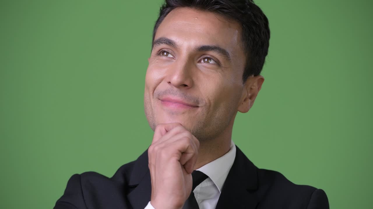 joven y guapo hombre de negocios hispano contra un fondo verde