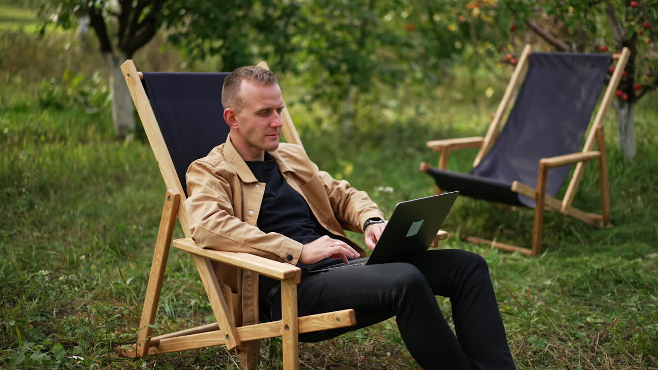 Man working on laptop in garden chair
