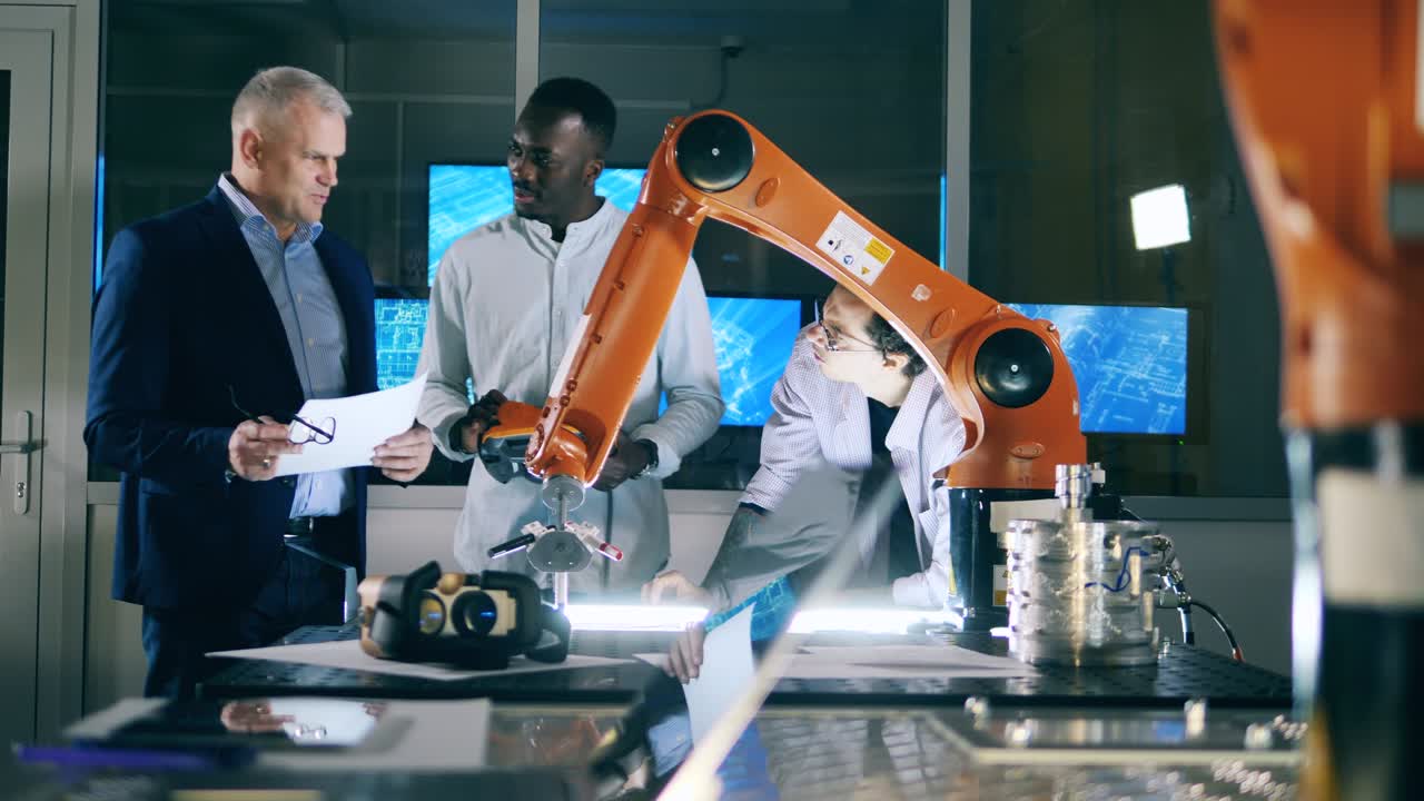 Group of male scientists are watching a robotic arm while drawing