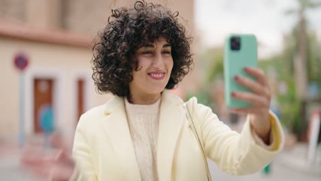 young woman smiling confident having video call at street