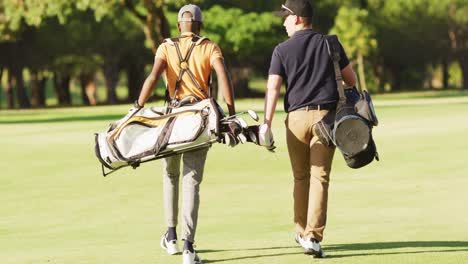 Video-Der-Rückansicht-Verschiedener-Männlicher-Freunde,-Die-Auf-Dem-Golfplatz-Spazieren-Gehen