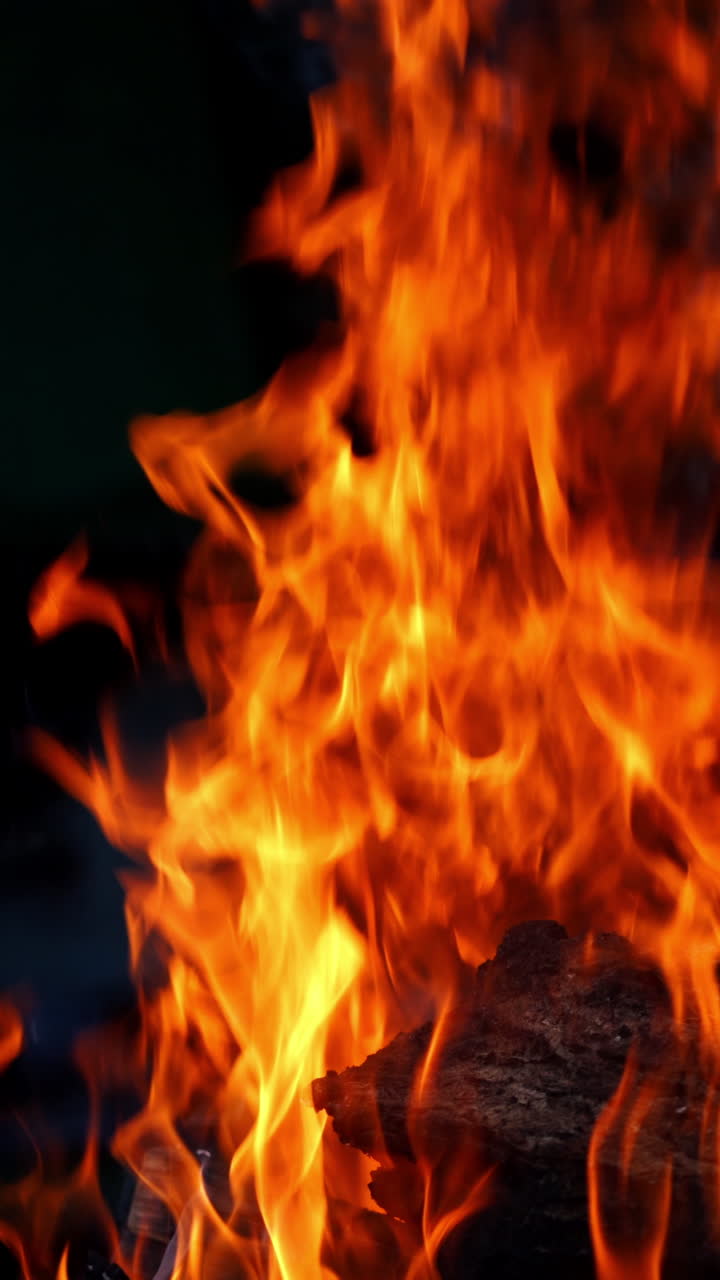 Bonfire burning at night. Burning logs in orange flames. Fire flame Vertical video