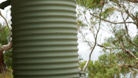 green water tank standing alongside a freestanding gazebo