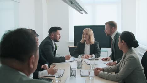 two business partners standing and shaking hands during business meeting