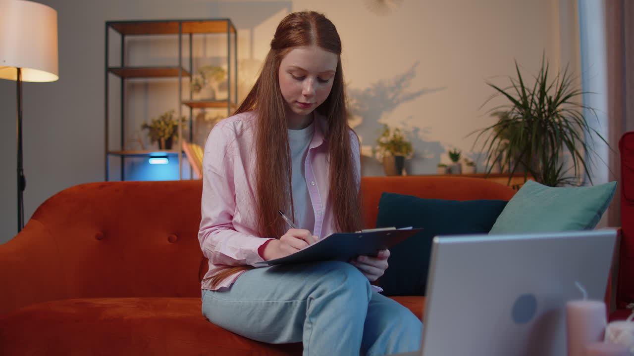 Child girl accounting payments calculating monthly expenses bank bills, analysing paperwork at home