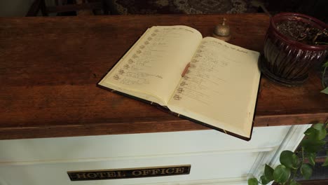 Historic-hotel-sign-in-book-with-bell-for-the-bellhop