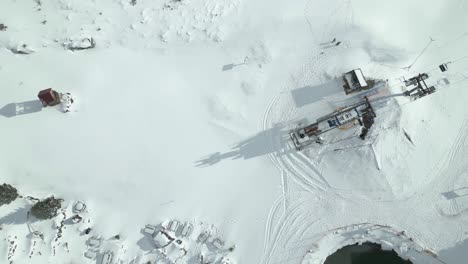 Aerial-drone-bird's-eye-view-over-people-going-up-the-mountain-by-chairlift-at-Engelberg-Brunni-bahnen-along-the-Swiss-alps-in-Switzerland-on-a-sunny-day