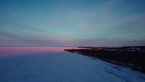 flying drone above a frozen lake in canada at golden hour