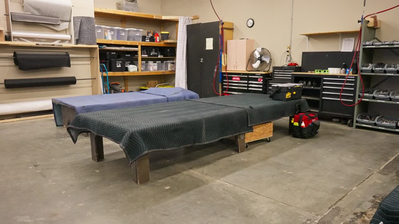 Slow-motion shows large work bench within an industrial furniture workshop