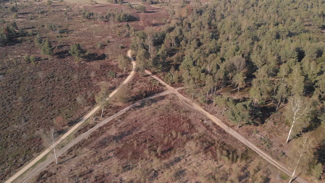 cruce de carreteras en un paisaje de páramo visto desde arriba retrocediendo mostrando los patrones de sendero más anchos