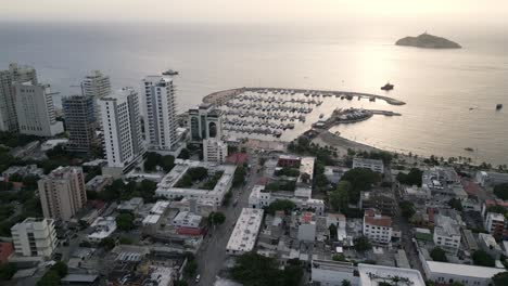 Vista-Panorámica-Aérea-De-La-Puesta-De-Sol-Sobre-Santa-Marta-Colombia-Marina-Yate-Bahía-Junto-Al-Mar-En-La-Playa-Caribeña,-Viajes-Y-Turismo