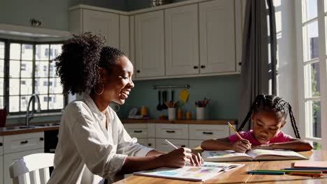mother and daughter drawing together at home