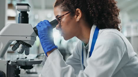 scientist examining sample under microscope in laboratory