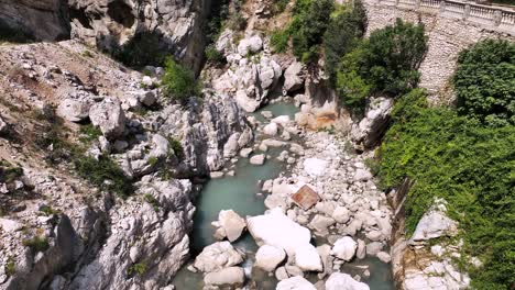 aerial shot of a river flowing through rocky riverbed in a canyon