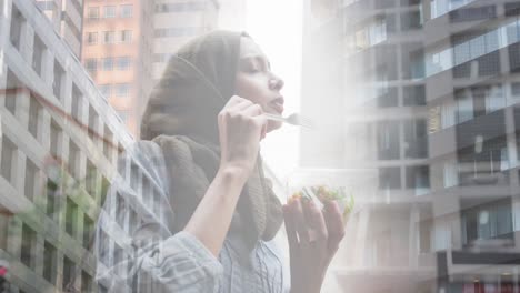 animation of asian woman in hijab enjoying salad, over cityscape