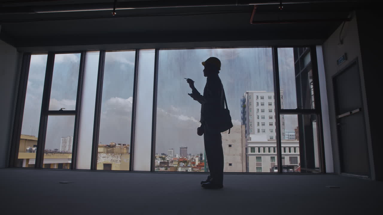 Silhouette of Construction Worker Measuring Sizes of Room