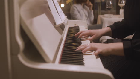 Curly-Woman-Playing-Piano-At-Restaurant