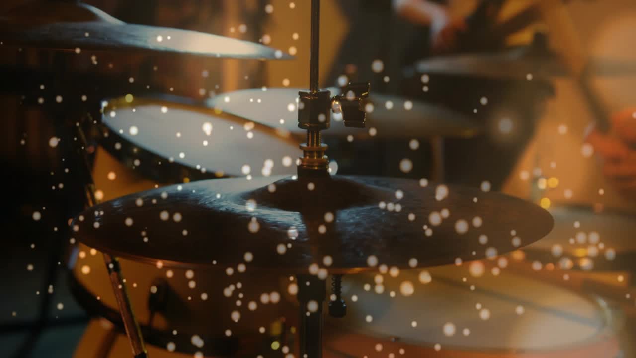 La telecamera mette a fuoco il charleston, particelle fluttuano, le bacchette colpiscono mentre il bassista si sincronizza e prova.