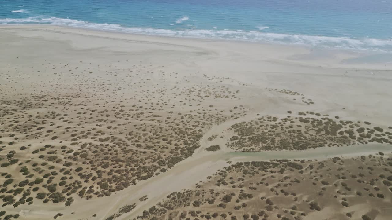 Stunning aerial drone footage of Sotavento Beach in Fuerteventura, Canary Islands. Golden sand, turquoise ocean water, and natural tidal lagoons. Travel, tourism, nature, and coastal lifestyle