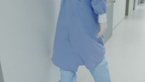 side view of worried caucasian male doctor walking in the corridor