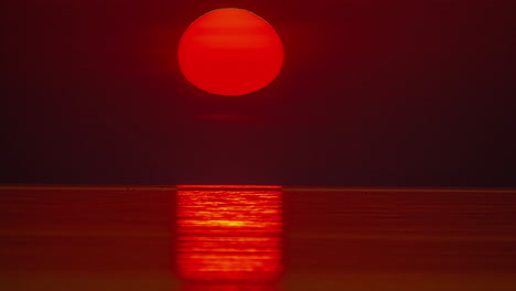 Toma-Estática-Del-Sol-Saliendo-Sobre-El-Océano-Pacífico-Sobre-El-Cielo-Rojo-Con-La-Vista-De-Las-Olas-Del-Mar-Al-Amanecer