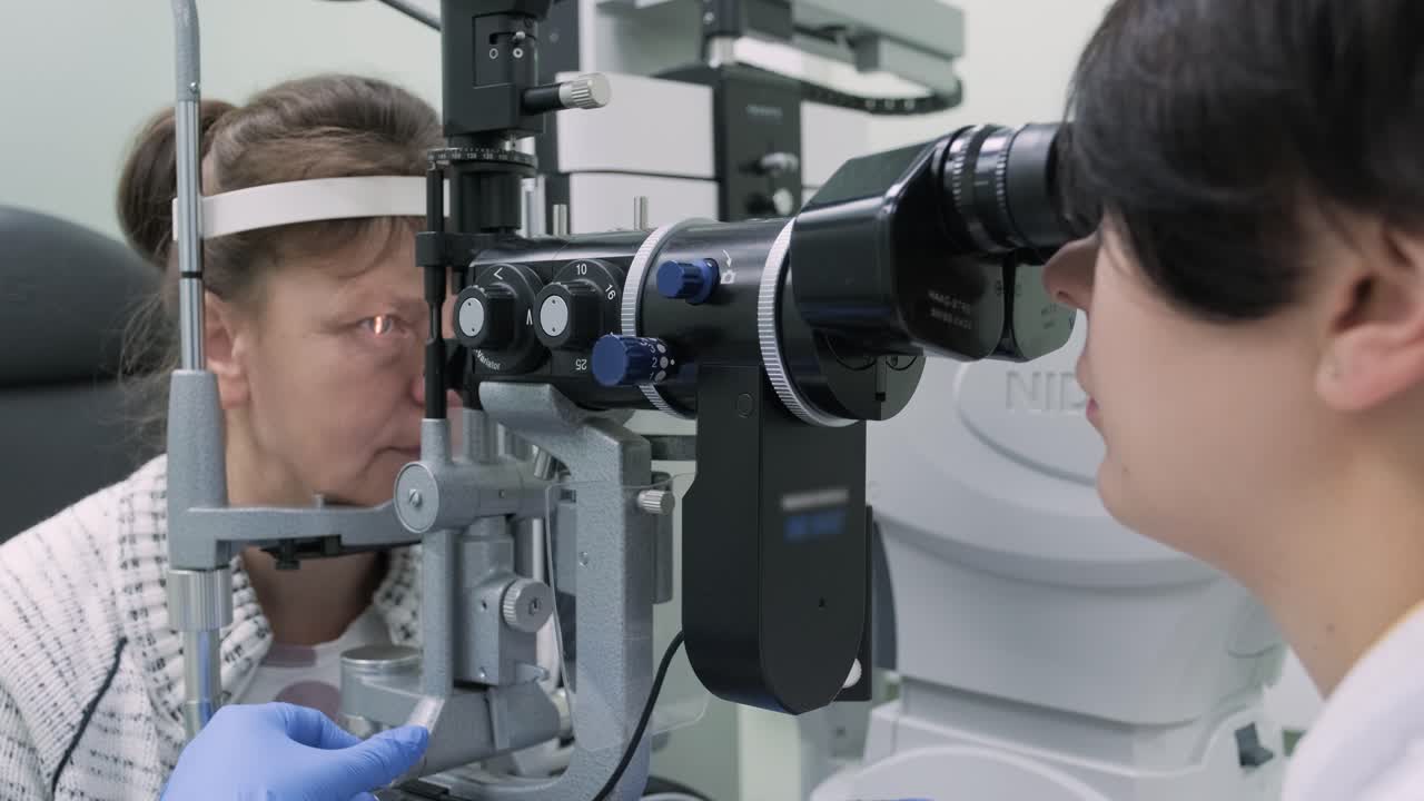 la mujer está viendo a través del oftalmoscopio en los ojos del paciente en la clínica oftalmológica. inspección profesional de la visión
